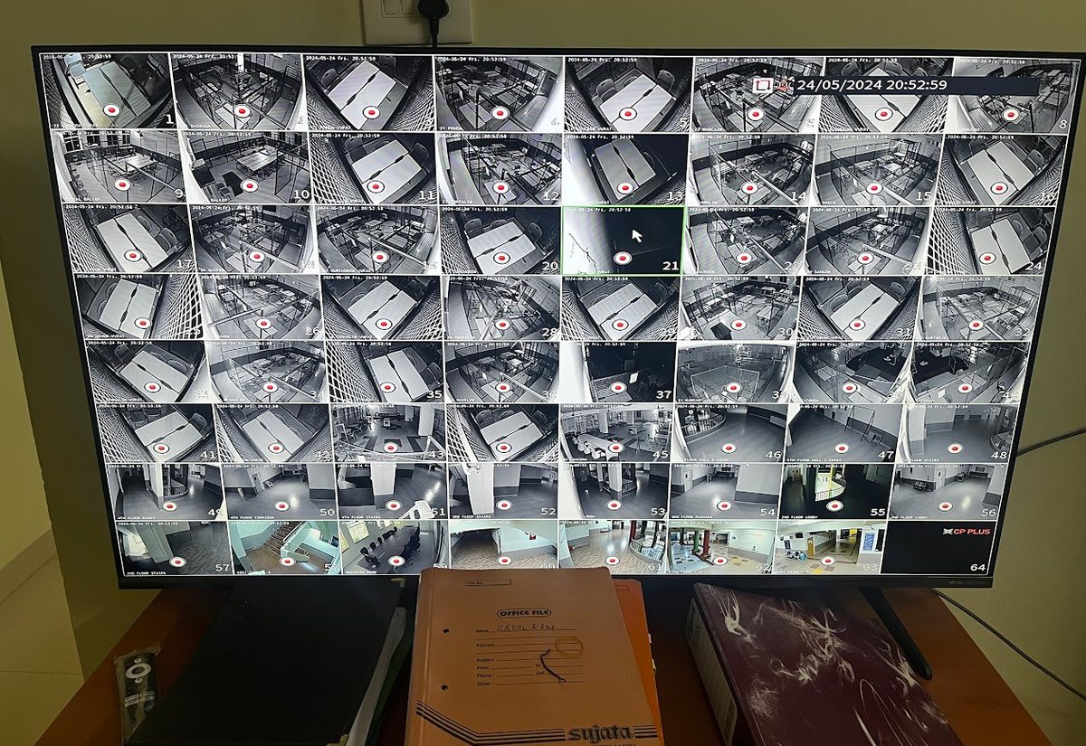 The deployed control wall for the Goa election surveillance system: a 64-camera grid showing strongroom and counting-hall feeds during the sealed-vault period